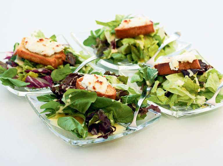 Pancito con queso de cabra sobre mézclum de lechugas